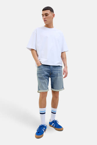 Jeansshort van JACK & JONES JEANS INTELLIGENCE in mid blue denim, gecombineerd met een wit t-shirt en blauwe sneakers.
