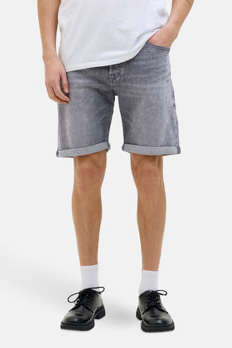 Grijs denim jeansshort van JACK & JONES JEANS INTELLIGENCE, met opgerolde pijpen, gecombineerd met witte sokken en zwarte schoenen.
