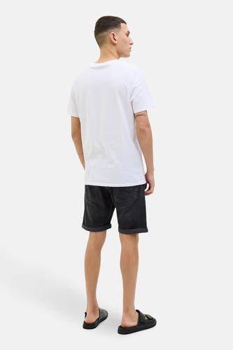 Donkergrijze jeansshort van JACK & JONES JEANS INTELLIGENCE, met opgerolde pijpen, gedragen met een wit T-shirt en zwarte sandalen.