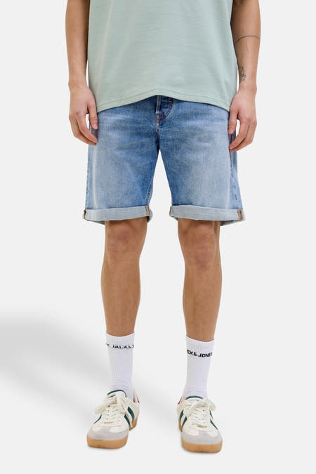 Jean court en denim bleu clair de JACK & JONES JEANS INTELLIGENCE, porté avec des chaussettes blanches et des baskets.