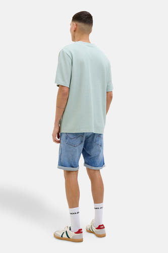 Jean court en denim bleu clair de JACK & JONES JEANS INTELLIGENCE, avec des poches rabattues et associé à un T-shirt bleu clair.