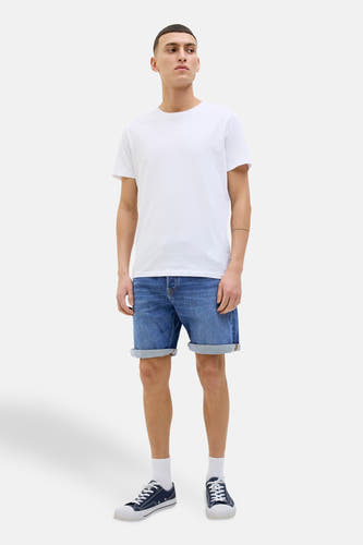 Denim jeansshort in mid blue van JACK & JONES JEANS INTELLIGENCE, gedragen met een wit T-shirt en sneakers.
