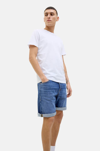 Denim jeansshort in mid blue van JACK & JONES JEANS INTELLIGENCE, met omgeslagen zoom en model draagt wit T-shirt.
