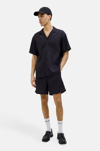Zwarte short van JACK & JONES JEANS INTELLIGENCE, gedragen met een bijpassend shirt, sokken en schoenen.
