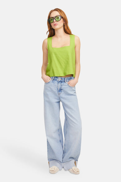 Groene mouwloze blouse van JJXX, met wijde jeans en zonnebril.