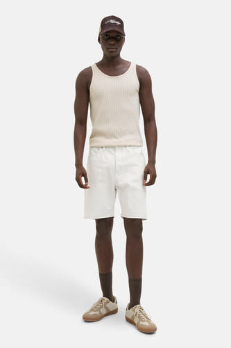 Ecru jeansshort van JACK & JONES JEANS INTELLIGENCE, gedragen met een beige hemdje en bruine accessoires.