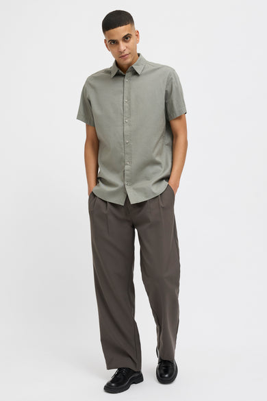 T-shirt kaki à manches courtes de PREMIUM BLUE par JACK & JONES, avec une subtile texture, porté avec un pantalon foncé.