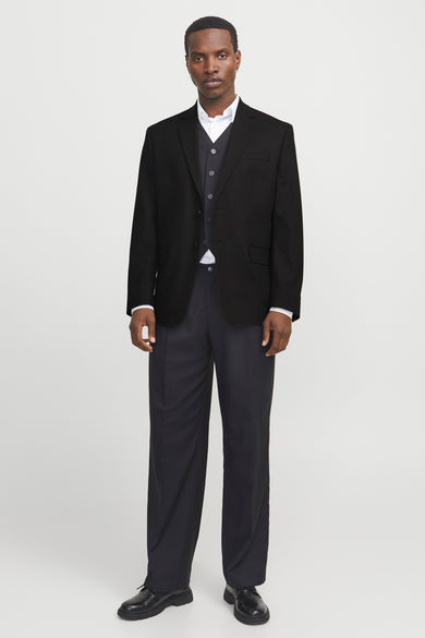 Zwarte blazer van PREMIUM by JACK & JONES, met een vest en een wit overhemd eronder.
