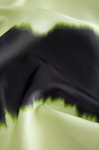Groene blouse van JJXX met zwarte verfachtige details en subtiele stofplooien.

