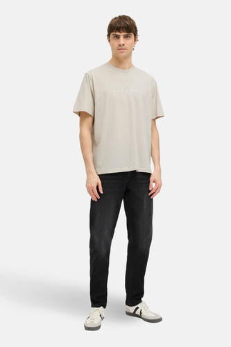 Beige T-shirt met korte mouwen van JJREBEL, met rechte pasvorm, gecombineerd met een donkere jeans en sportschoenen.