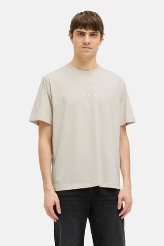 T-shirt beige à manches courtes de JJREBEL, d'une couleur unie et associé à des jeans noirs et des baskets.