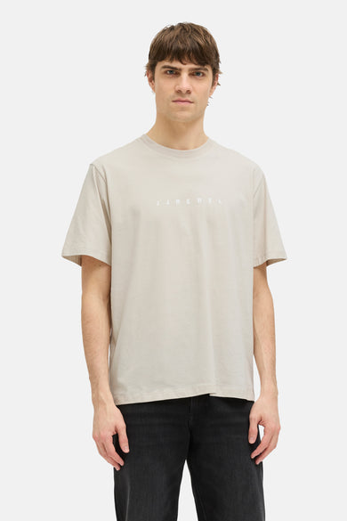 T-shirt beige à manches courtes de JJREBEL, d'une couleur unie et associé à des jeans noirs et des baskets.