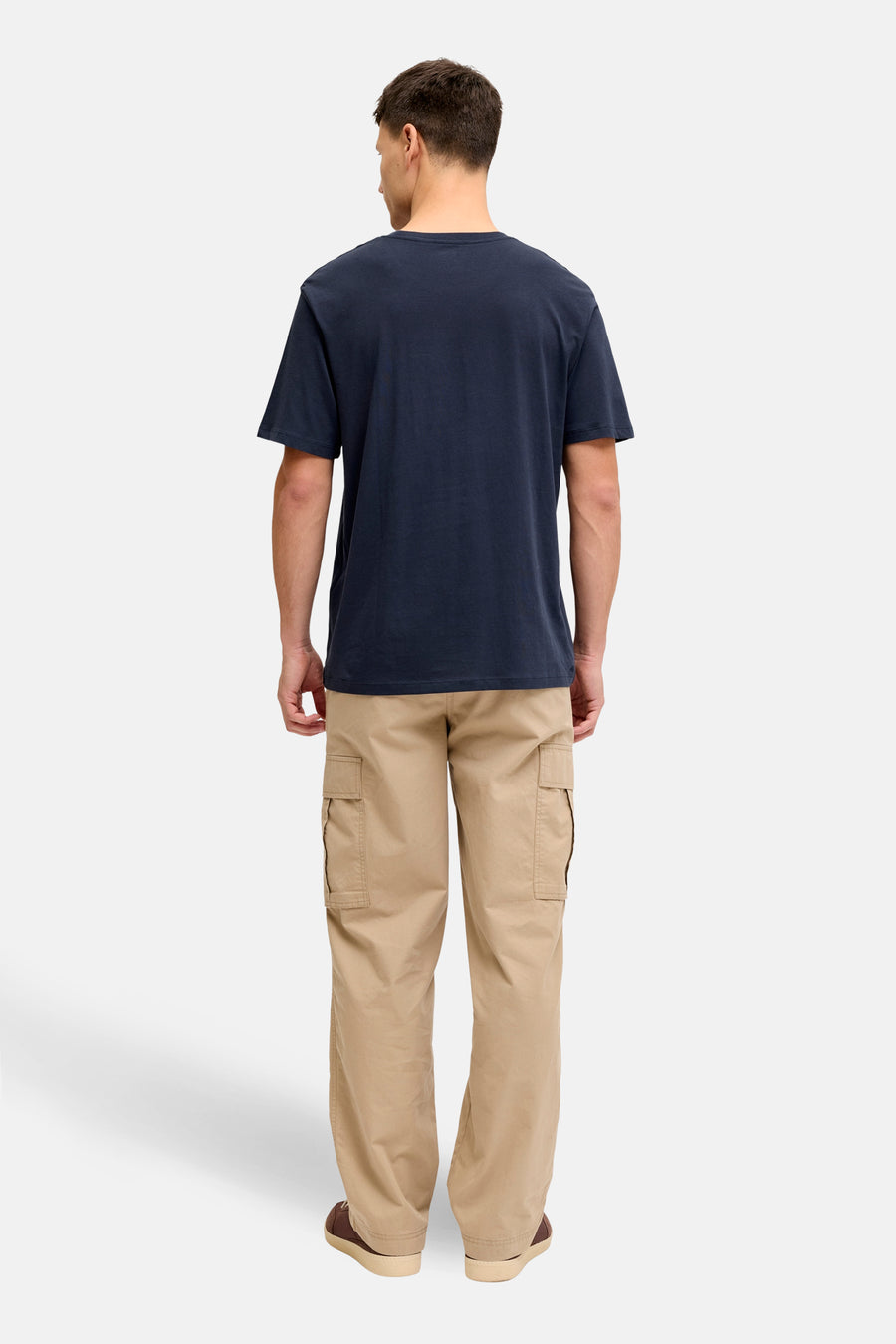 T-shirt bleu à manches courtes de JJREBEL, vu de derrière, avec un pantalon cargo kaki et des chaussures marron foncé.