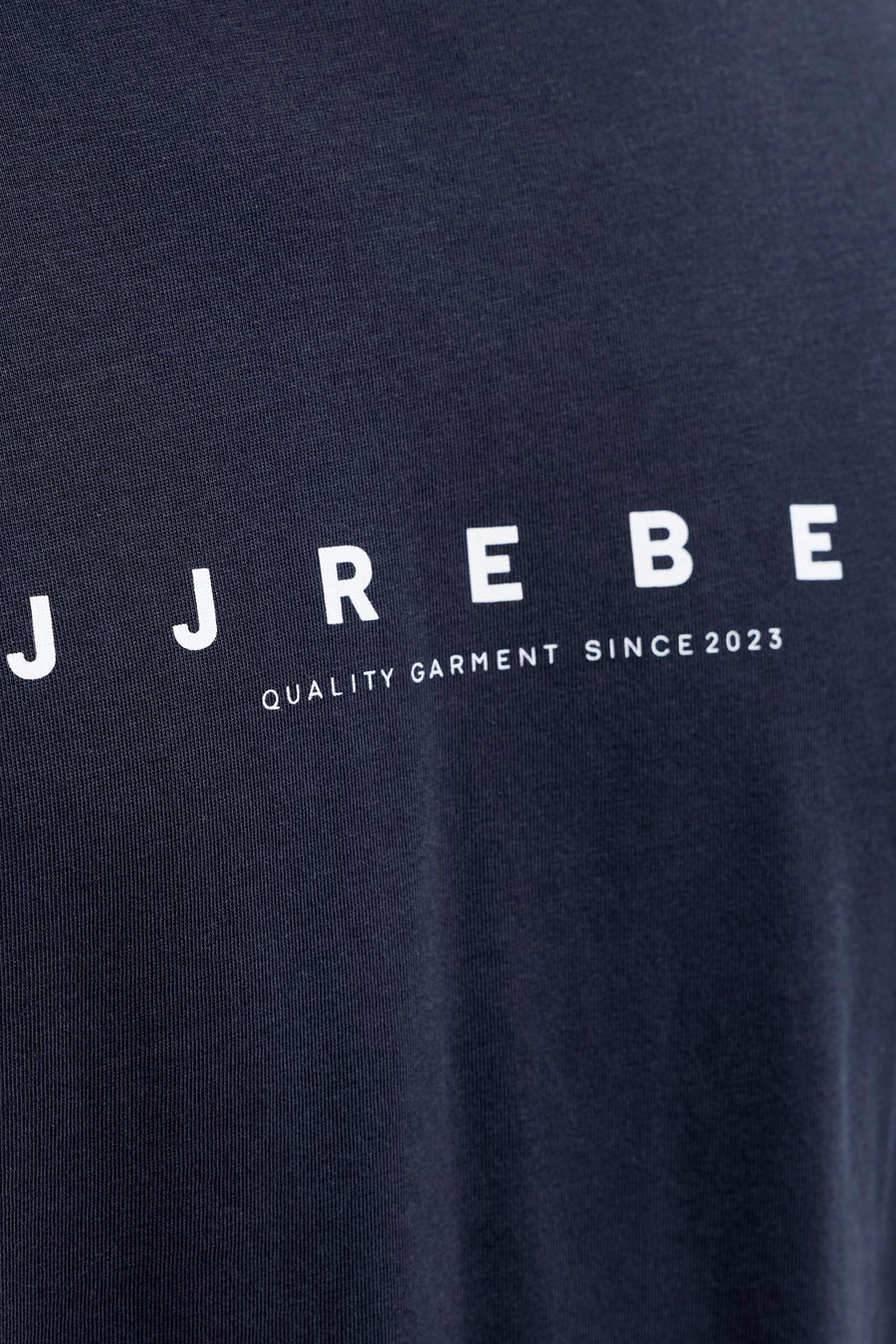 T-shirt bleu à manches courtes de JJREBEL, avec une impression de texte blanche "Vêtement de qualité depuis 2023".