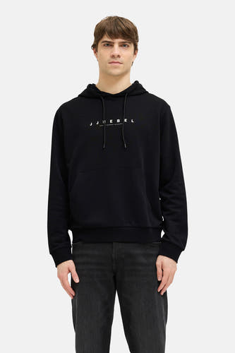 Zwarte sweater met capuchon van JJREBEL, met lange mouwen en een buidelzak, gecombineerd met een zwarte jeans.
