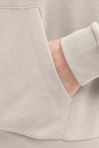 Beige sweater met kap van JJREBEL, met een hand in de zak, zachte textuur en geribbelde manchetten.