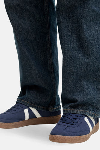 Baskets bleues de ACCESSORIES BY JACK & JONES, avec des rayures blanches et une semelle marron, portées avec un jean bleu foncé.