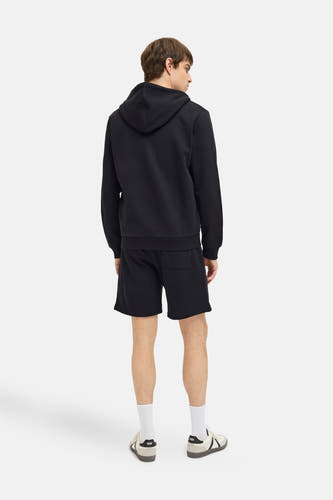 Short noir de JJREBEL, avec un design simple et combiné à une hoodie noire et des chaussettes blanches.