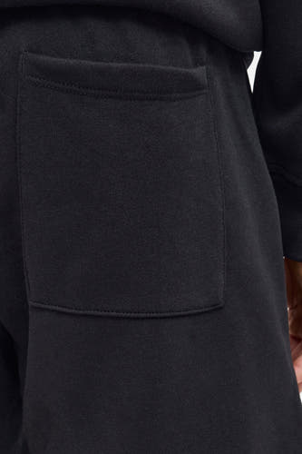 Short noir de JJREBEL, avec une poche brodée sur le dos.