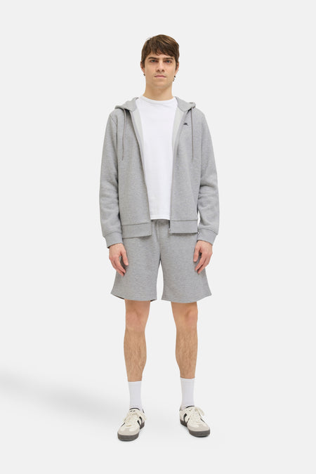 Short gris de JJREBEL, associé à un t-shirt blanc et des chaussettes blanches avec des chaussures noires.