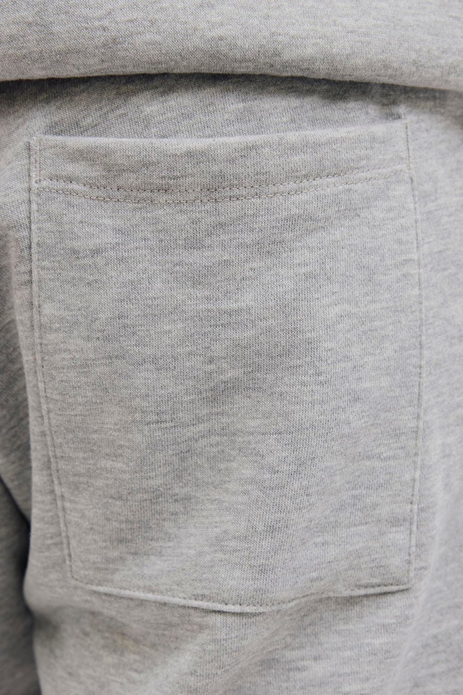 Veste grise de JJREBEL, avec une poche arrière et une texture jersey douce.