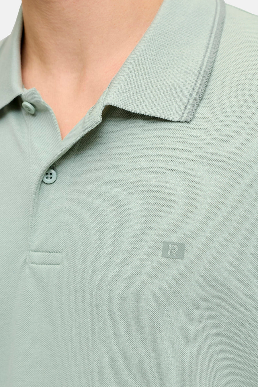 Polo verte JJREBEL en piqué avec col, fermeture à deux boutons et logo 'R' discret sur la poitrine.