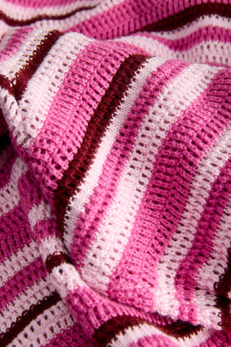Roze gebreide broek van JJXX met strepen in lichtroze, felroze en bordeaux, en een opengewerkte textuur.
