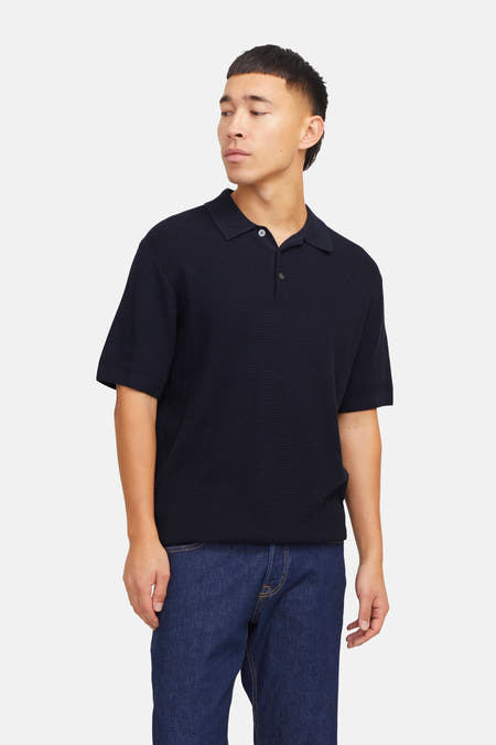 Blauwe polo met korte mouwen van PREMIUM by JACK & JONES, gedragen met een jeansbroek.
