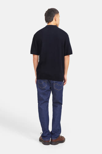 Polo bleu à manches courtes de PREMIUM by JACK & JONES, vu de dos, avec des jeans foncés et des chaussures marrons.
