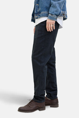 Blauwe chino van JACK & JONES JEANS INTELLIGENCE, met bruine leren schoenen en een spijkerjasje, zij-aanzicht.
