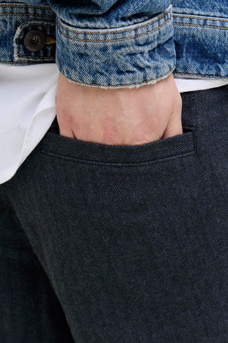 Blauwe chino van JACK & JONES JEANS INTELLIGENCE, met visgraatmotief en een hand in de zak.

