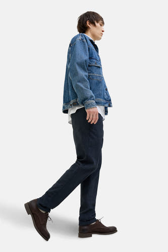 Blauwe chino van JACK & JONES JEANS INTELLIGENCE, gecombineerd met een denim jack en bruine schoenen, in een zijwaartse weergave.
