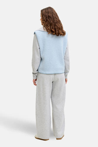 Gilet bleu JJXX, en une douce texture fleece, porté avec un pull gris et un pantalon de jogging large, dos.