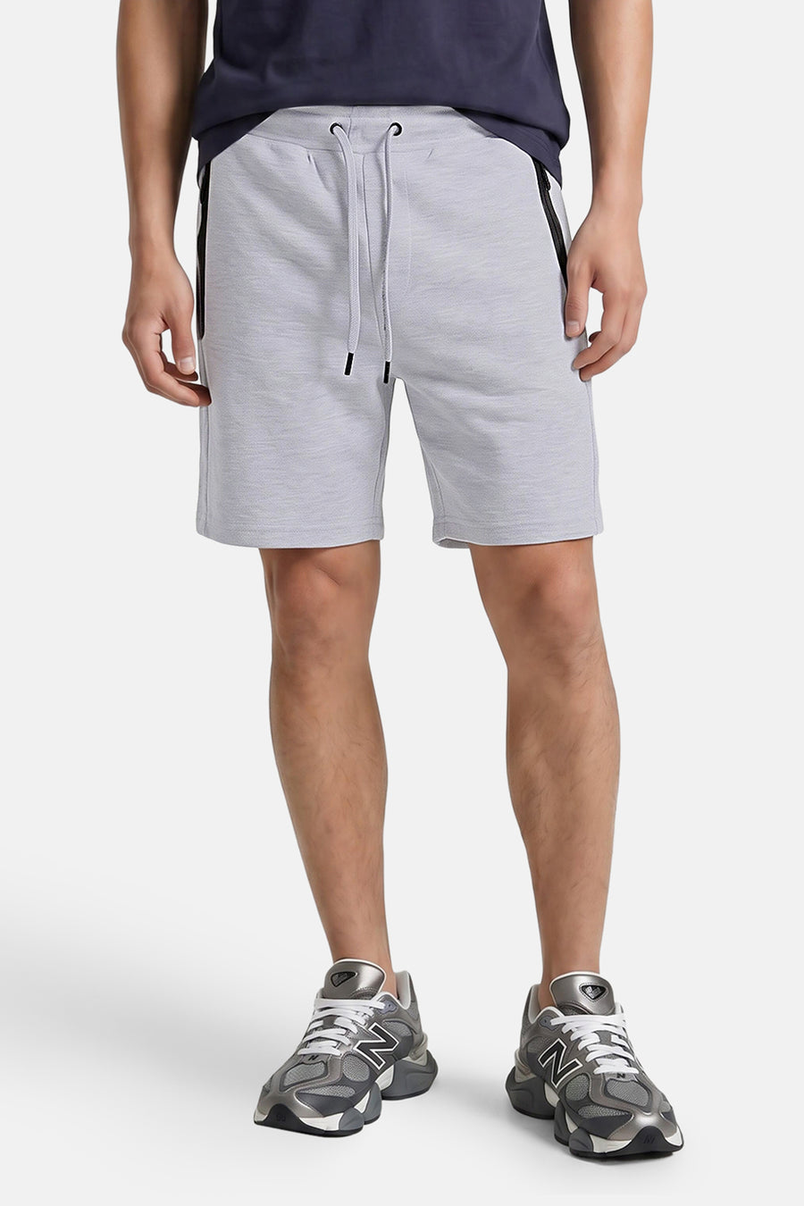 Grijze katoenen shorts van JACK & JONES JEANS INTELLIGENCE met trekkoord, zijzakken en zwarte ritsdetails, front view op model met donkerblauw shirt en grijze sneakers