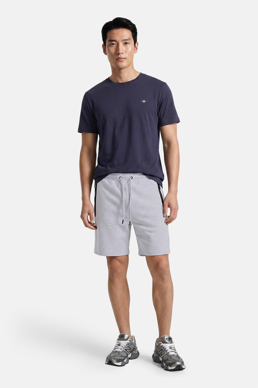 Grijze heren shorts van JACK & JONES JEANS INTELLIGENCE met elastische tailleband en trekkoord, lichte melange textuur, zijkant met donkere accentstrepen, full body lifestyle view