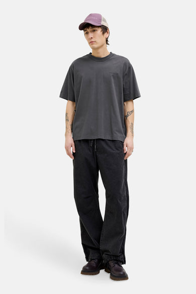 Grijs T-shirt met korte mouwen van CORE BY JACK & JONES, gedragen met een pet en zwarte pantalon.