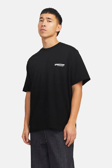 Zwart T-shirt met korte mouwen van CORE by JACK & JONES, met witte tekst op de borst, gedragen met donkerblauwe jeans.
