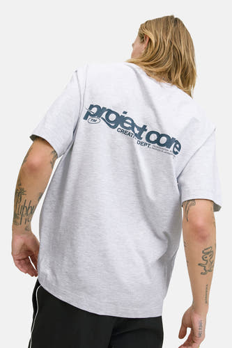 Grijs T-shirt met korte mouwen van CORE BY JACK & JONES, rugzijde met donkerblauwe tekstprint, gecombineerd met zwarte broek.
