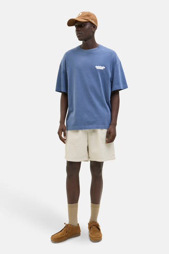 Ecru short van JACK & JONES JEANS INTELLIGENCE, gecombineerd met een blauw T-shirt, bruine sokken en suède schoenen.