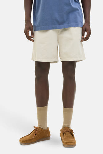 Ecru short van JACK & JONES JEANS INTELLIGENCE, gecombineerd met bruine suède schoenen en beige sokken.
