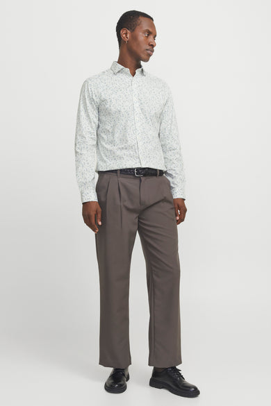 Chemise blanche à manches longues de PREMIUM by JACK & JONES, avec un fin motif floral, associée à des pantalons marrons et des chaussures noires.