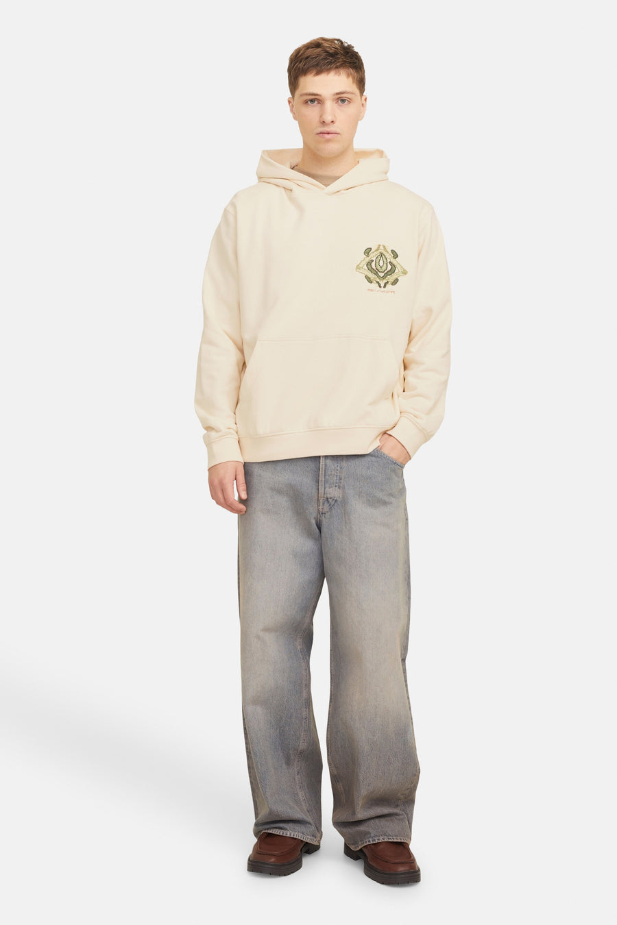 Ecru sweater met kap van ORIGINALS BY JACK & JONES, met geborduurde grafische details op de borst, gecombineerd met wijde jeans en bruine schoenen.
