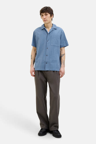 Chemise bleue à manches courtes de PREMIUM BLUE par JACK & JONES, avec une subtile texture et portée avec un pantalon foncé.