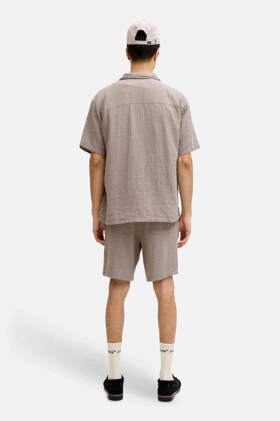 Bruine short van ORIGINALS BY JACK & JONES, met een geruit patroon, gecombineerd met witte sokken en zwarte schoenen, gezien van achteren.
