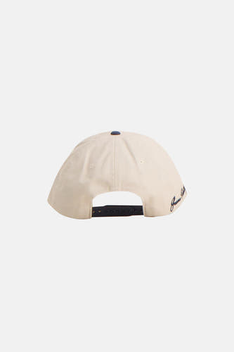 Beige pet van ACCESSORIES BY JACK & JONES met een zwarte sluiting aan de achterkant en een geborduurde tekst op de zijkant.