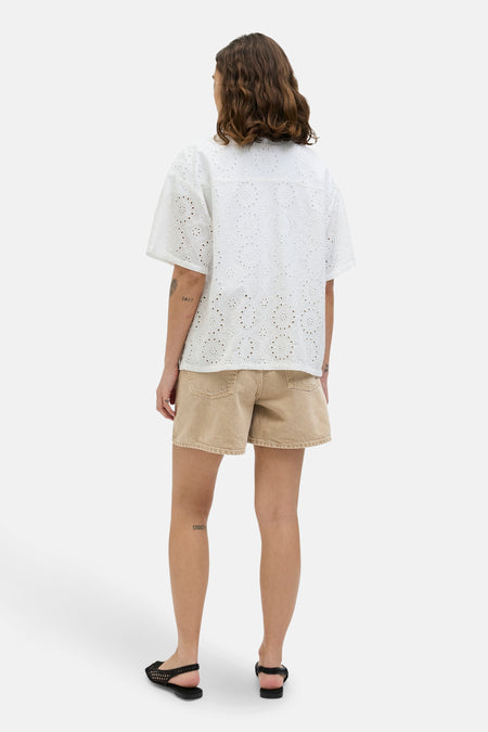 Short beige de JJXX, avec une coupe décontractée et des tatouages visibles sur les jambes.