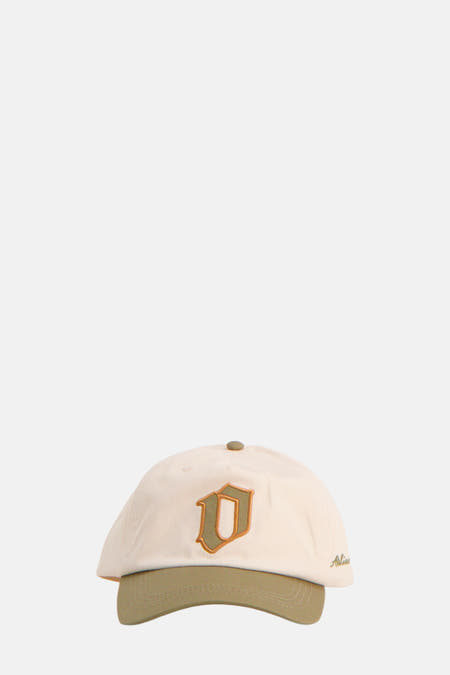 Ecru pet van ACCESSORIES BY JACK & JONES, met groene klep en een geborduurde letter "D".