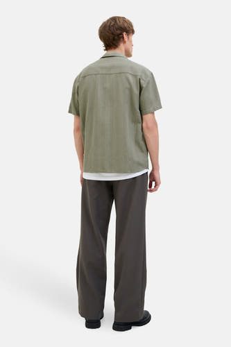 Groen hemd met korte mouwen van PREMIUM BLUE by JACK & JONES, met een subtiel verticaal streepjespatroon, gedragen met een wit shirt en grijze broek.