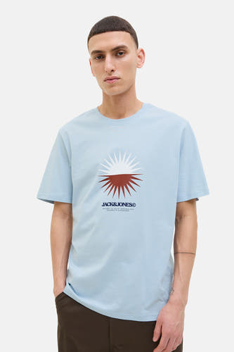 T-shirt bleu à manches courtes d'ORIGINALS BY JACK & JONES, avec une impression graphique sur la poitrine, porté avec un pantalon marron.