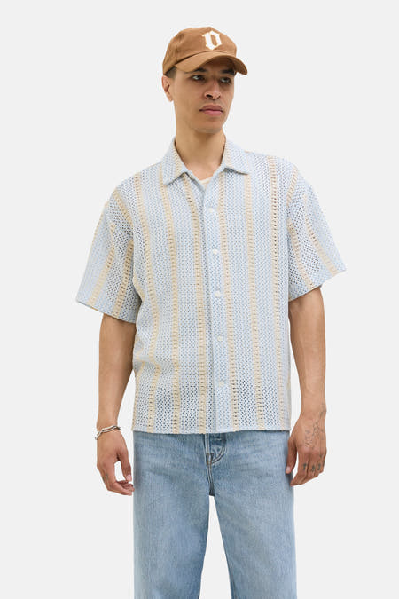 Lichtblauw overhemd met korte mouwen van ORIGINALS BY JACK & JONES, met verticaal gestreept haakpatroon, gedragen met een pet en spijkerbroek.
